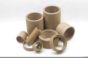 Cardboard cores of different sizes for winding various strips of material in the printing house. Industrial paper cores, tube and spools on a white background. Selective focus.
